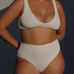 Textured white flattering scoop neck bikini top with thick shoulder straps and adjustable tie-back. 