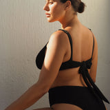 High-waisted black bikini bottom with a cheeky cut back, crafted from premium textured 5D fabric.