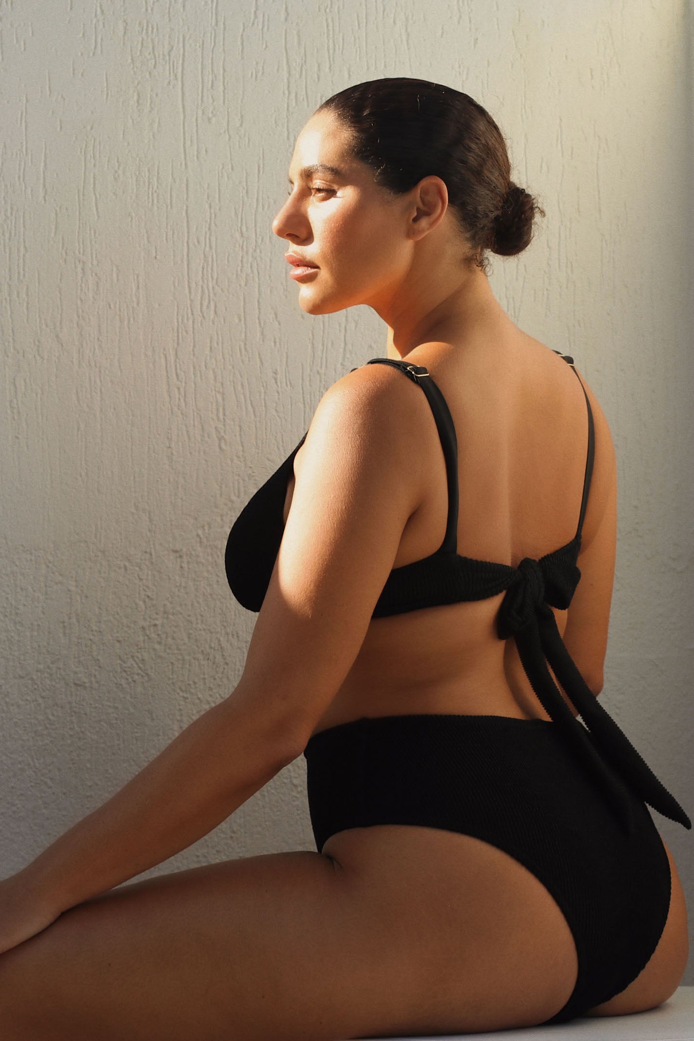 High-waisted black bikini bottom with a cheeky cut back, crafted from premium textured 5D fabric.