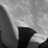 High-waisted black bikini bottom with a cheeky cut back, crafted from premium textured 5D fabric.