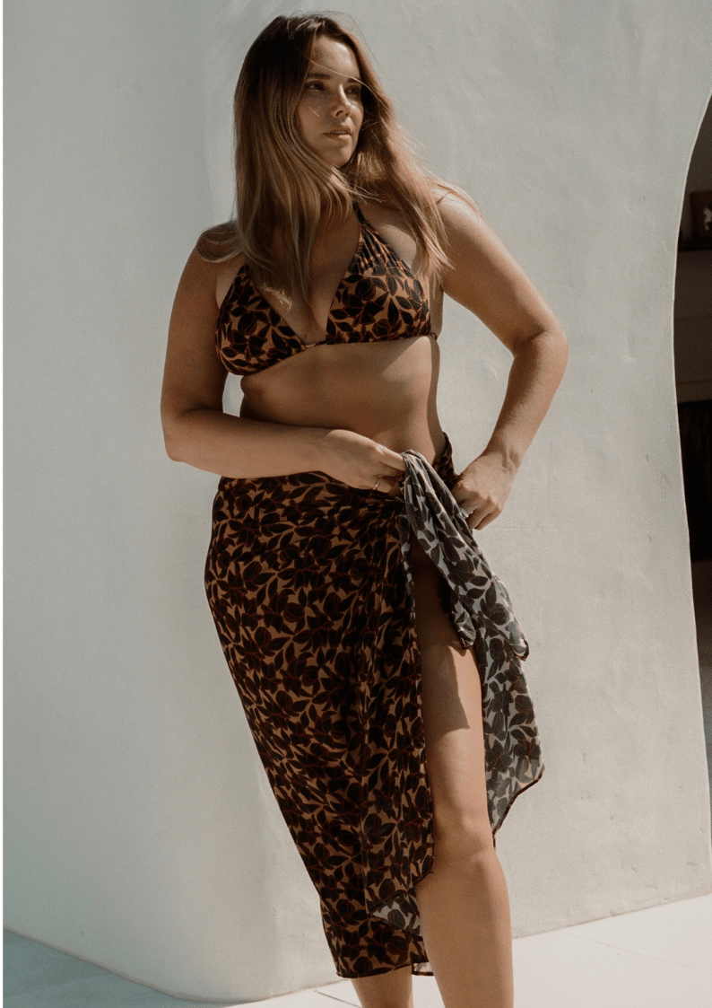 Bree McCann wearing bokumaia noir hibiscus floral sarong styled with matching bikini high waist beach wrap cover up