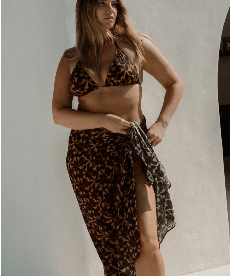 Bree McCann wearing bokumaia noir hibiscus floral sarong styled with matching bikini high waist beach wrap cover up
