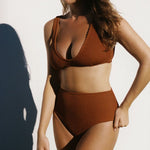Women wearing brown rust caramel D+ bikini top and high waisted bikini bottom in textured fabric. 