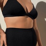 Woman wearing Bokumaia black textured triangle bikini top with supportive plunge fit and seamless shaping.