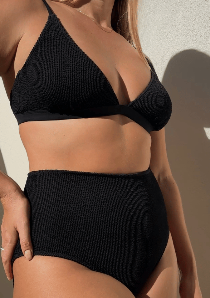 Woman wearing Bokumaia black textured triangle bikini top with supportive plunge fit and seamless shaping.