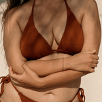 Person wearing a brown triangle bikini against a neutral background