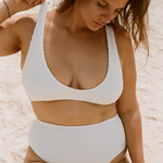 Woman wearing a white high waisted bikini on a beach